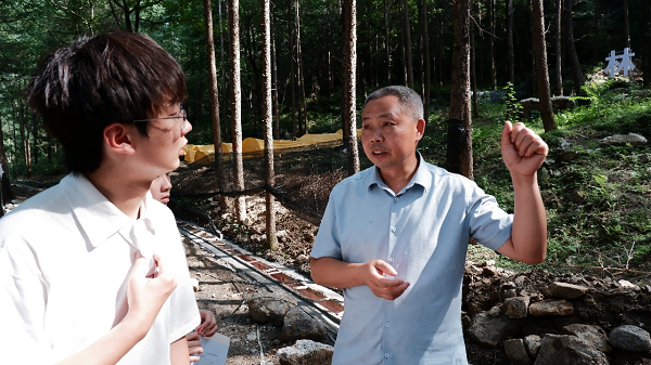 支部党员听当地村书记讲解西洋参种植要点.png