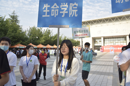 308ec3123771424eb15d06446ddee18c.jpg 志愿者举牌指引新生.JPG